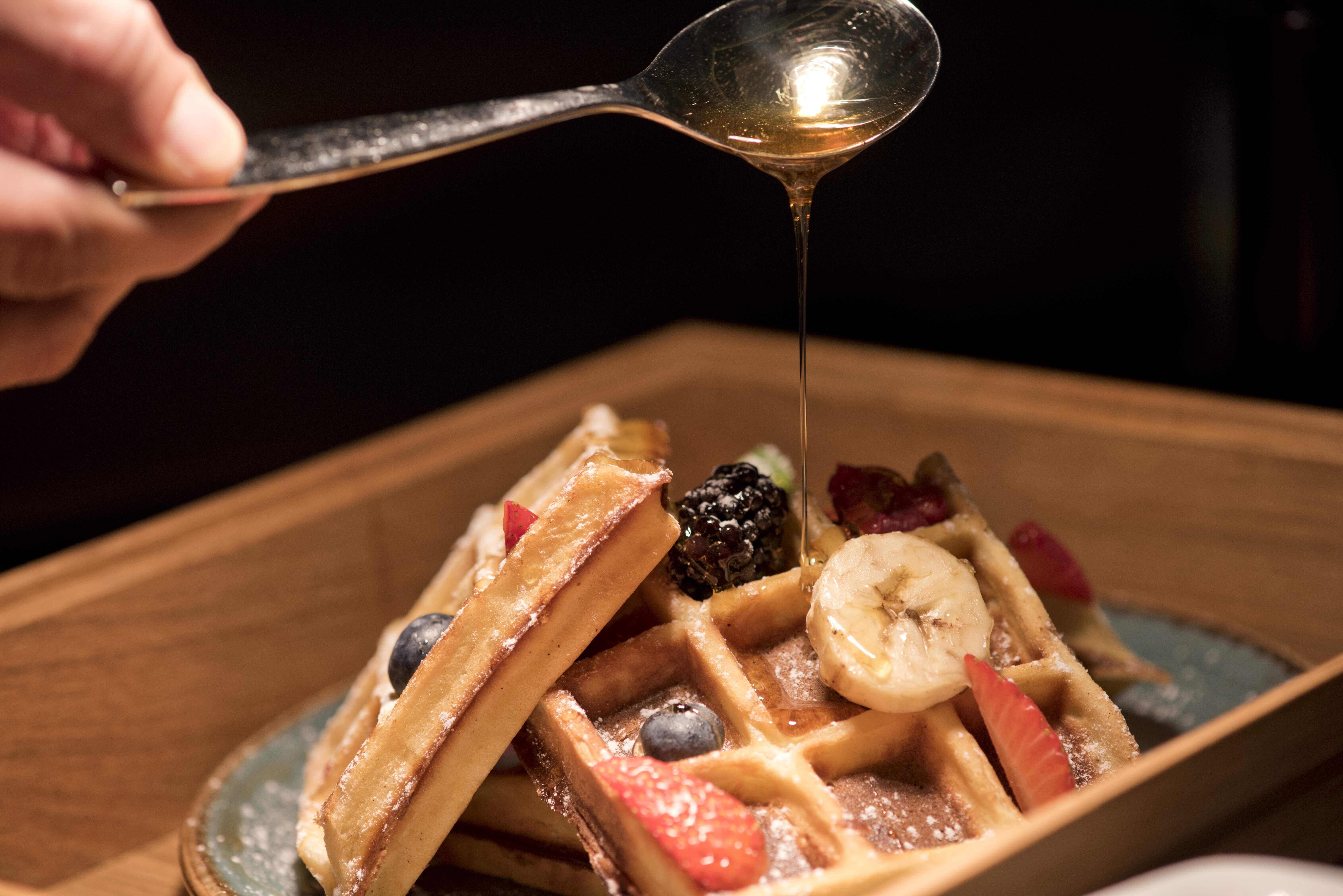 Voco Doha West Bay Suites By Ihg Exterior photo Maple syrup being drizzled on a plate of waffles